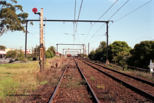 121-30
Morwell station yard overview looking from SEC or Briquette sidings road, signal Post 10, track at right is mainline to Traralgon, RT class rail tractor and station building in background.

