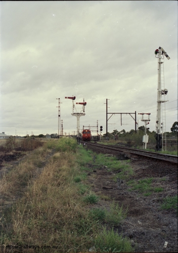 123-2-21
Sunshine track view, Newport - Sunshine Loop Line, looking towards Sunshine, double doll semaphore signal posts 36 and pulled off semaphore signal post 49, G class arriving with an up Brooklyn bound Apex quarry train.
