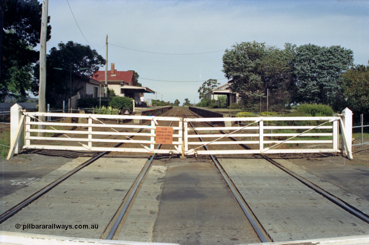 128-20
Gisborne, Gisborne Road grade crossing, non-interlocked swing gates, looking south in the Up direction from middle of the road, station buildings, track view.
