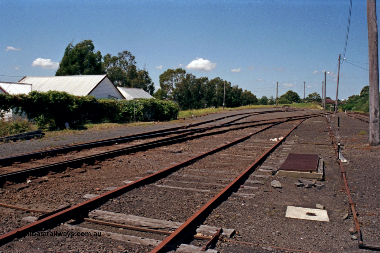 129-2-16
Korumburra yard overview, looking down direction on No. 2 Road, No 1 Road on the left with loco tracks branching off mainline curving towards the bridge in the distance.
