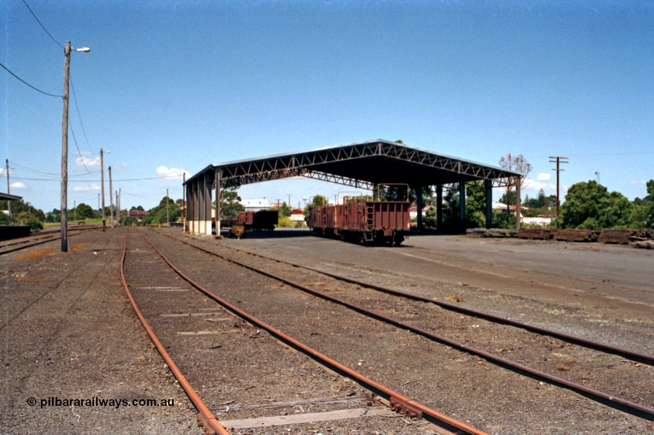 129-2-19
Korumburra station yard overview, showing Freightgate canopy, sleeper waggons, goods shed behind, looking in the down direction.

