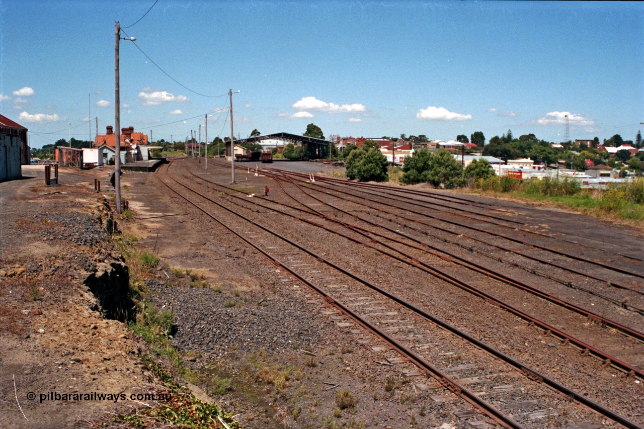 129-2-21
Korumburra station yard overview looking down direction, shows former Works Depot siding removed from alongside embankment, Freightgate canopy and overview of yard.

