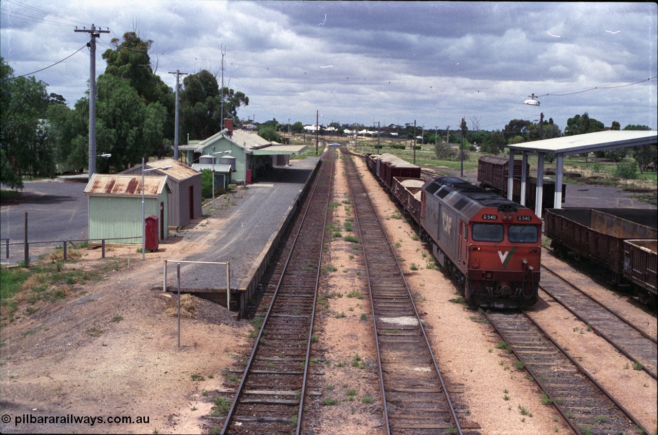 132-04
Ouyen station overview, broad gauge V/Line G class G 540 Clyde Engineering EMD model JT26C-2SS serial 89-1273 with stabled up gypsum train 9138, looking south from footbridge, station building and platform, Freightgate canopy with empty open bogie waggons.
Keywords: G-class;G540;Clyde-Engineering-Somerton-Victoria;EMD;JT26C-2SS;89-1273;