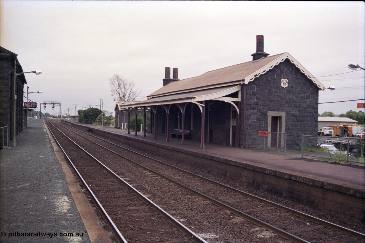 133-05
Little River, station building view, looking from up platform, bluestone buildings, Geelong line, signal gantry.

