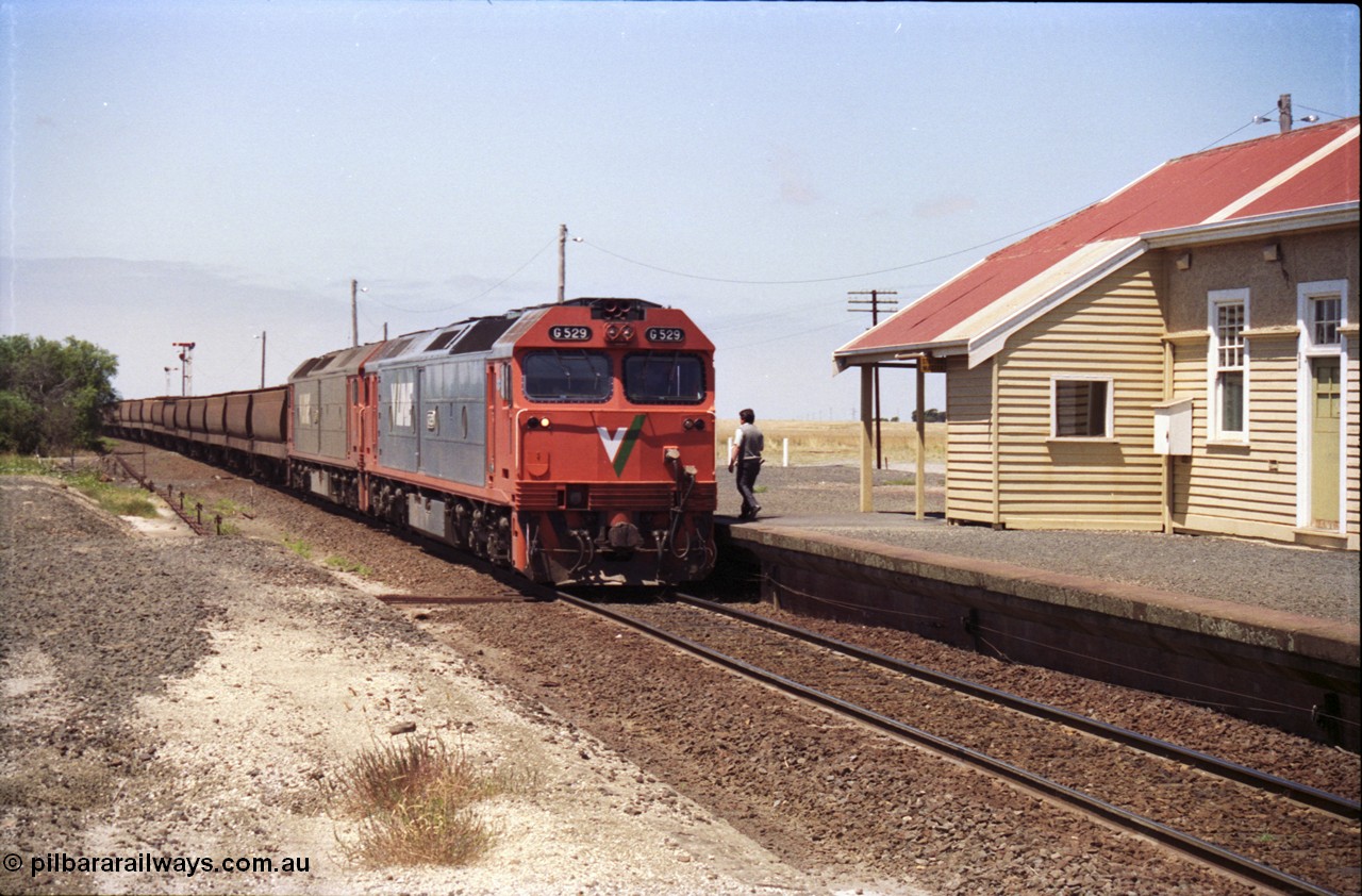 133-16
Gheringhap station building, V/Line broad gauge grain train 9121 heading to Ballarat and beyond, G classes G 529 Clyde Engineering EMD model JT26C-2SS serial 88-1259 and G 511 serial 84-1239 pause to exchange electric staves, safeworking.
Keywords: G-class;G529;Clyde-Engineering-Somerton-Victoria;EMD;JT26C-2SS;88-1259;