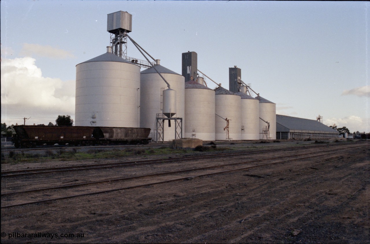 136-11
Deniliquin silo complex overview with Ascom style silos and a horizontal Victorian Oats Pool shed, yard view, broad gauge V/Line VHGF and VHGY class bogie grain waggons still in VR arrow livery.
Keywords: VHGF-type;VHGY-type;