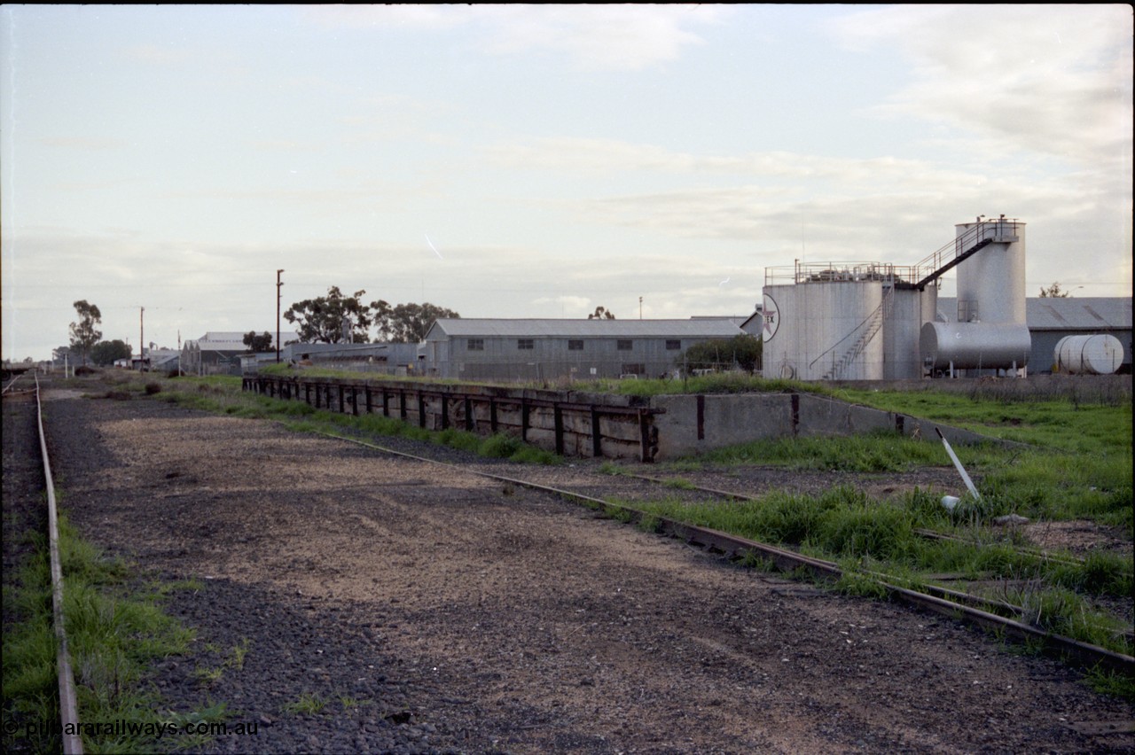 136-22
Deniliquin yard view, derelict loading ramp and platform, Caltex fuel facility behind, located opposite the Victorian Oats Pool shed, looking north towards Wood St.
