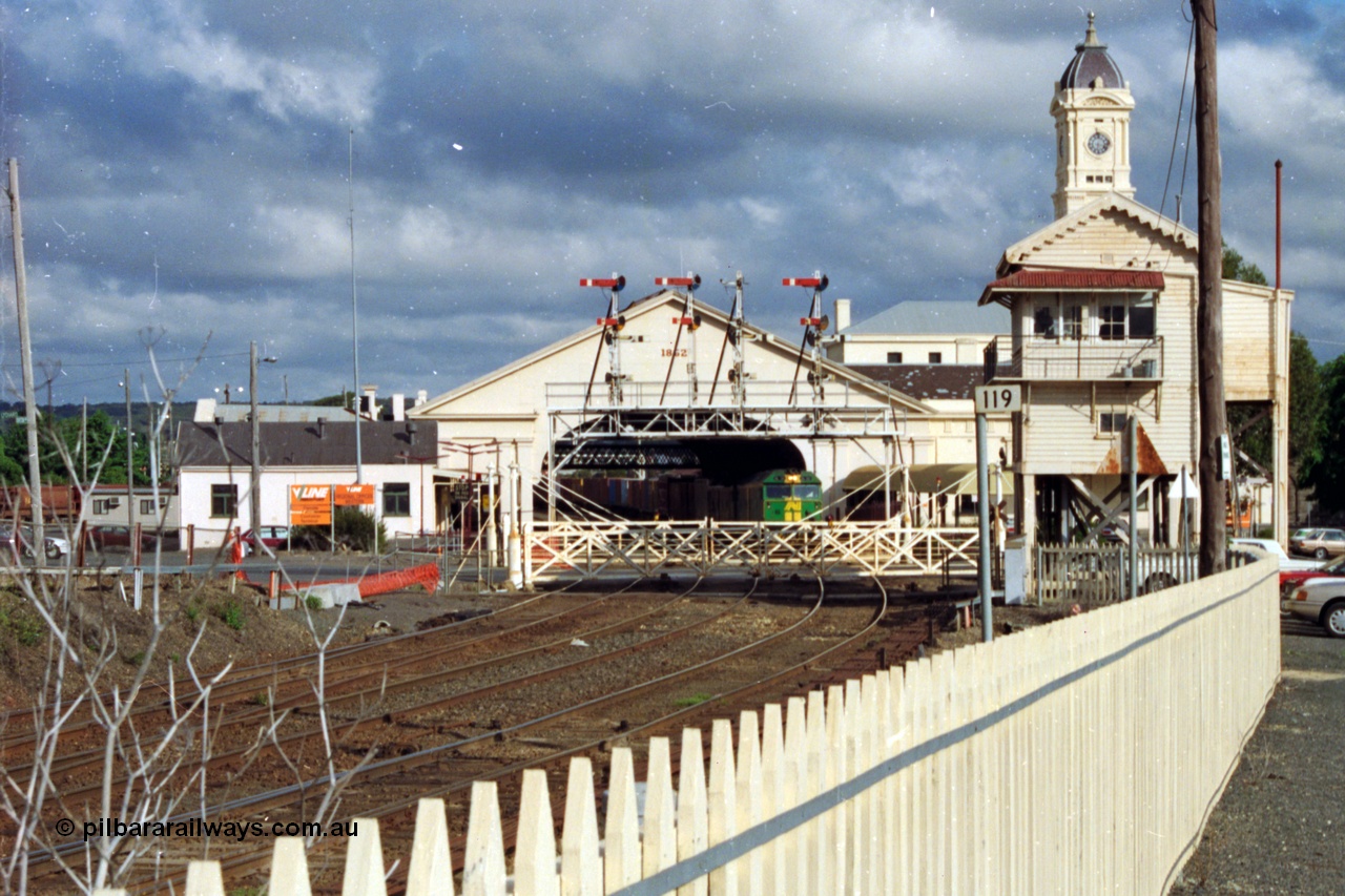 139-19
Ballarat, Australian National broad gauge BL class BL 32 Clyde Engineering EMD model JT26C-2SS serial 83-1016 leading a down Adelaide goods pauses at Ballarat station under the canopy and clock tower, view of Lydiard Street Ballarat B signal box, interlocked gates and semaphore signal gantry, with triple track to double track junction, point rodding, interlocking and point indicator.
Keywords: BL-class;BL32;Clyde-Engineering-Rosewater-SA;EMD;JT26C-2SS;83-1016;