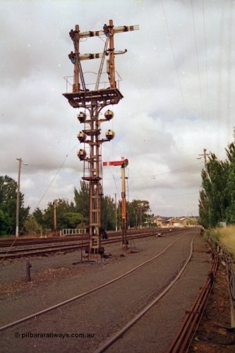 139-07
Ballarat yard, looking east, rear view of semaphore and disc signal post 11, semaphore signal post 9B facing the camera, Ballarat East signal box and goods shed visible in the background.
