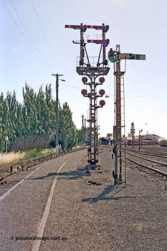 140-1-07
Ballarat station yard overview, combination semaphore and disc signal post 11 facing the camera and semaphore signal post 10 looking toward the station, Ballarat signal box A behind post 11, station clock tower and platform canopy on the right.
