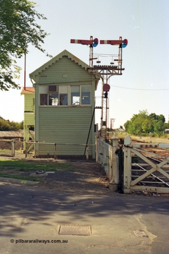 140-1-24
Ballarat North or C Signal Box, looking west, semaphore signal post 4, left arm is the Down Home to Ararat line, right arm is Down Home Maryborough line, and the disc is for the workshops sidings, the wheel for the interlocked swing gates can be seen in the window of the signal box.
