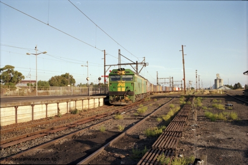 141-1-05
Sunshine, broad gauge down Adelaide goods train behind Australian National BL class BL 33 Clyde Engineering EMD model JT26C-2SS serial 83-1017 and V/Line G class G 515 Clyde Engineering EMD model JT26C-2SS serial 85-1243 pass platform No.3 as its consist crosses over the passenger lines from the Independent Through Lines heading the main western line, station platform, semaphore and disc signal posts, points, point rodding, looking east, Newport Loop Line on the right, GEB silo complex.
Keywords: BL-class;BL33;Clyde-Engineering-Rosewater-SA;EMD;JT26C-2SS;83-1017;
