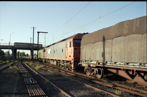 141-1-07
Sunshine, broad gauge down Adelaide goods train behind Australian National BL class BL 33 Clyde Engineering EMD model JT26C-2SS serial 83-1017 and V/Line G class G 515 Clyde Engineering EMD model JT26C-2SS serial 85-1243 pass platform No.3 with a down Adelaide bound goods train about to go under Hampshire Road overbridge, signal aspect of red over green, Clear Medium Speed, point rodding, former goods yard, V/Line broad gauge VQFY class bogie container flat waggon leads the consist.
Keywords: G-class;G515;Clyde-Engineering-Rosewater-SA;EMD;JT26C-2SS;85-1243;