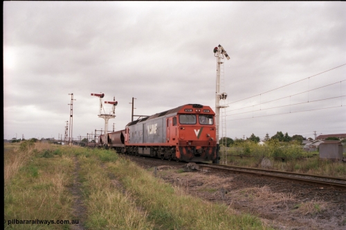 141-1-18
Sunshine, broad gauge V/Line G class loco G 538 Clyde Engineering EMD model JT26C-2SS serial 89-1271 leads the up afternoon Apex Quarry train to Brooklyn as it runs across the passenger lines and onto the Newport Loop Line, the semaphore signal post 36 protects down trains off this line. The dual control point machine is for the points into the GEB sidings, the up home semaphore and disc signal post 49 is pulled off for the train to head towards Brooklyn.
Keywords: G-class;G538;Clyde-Engineering-Somerton-Victoria;EMD;JT26C-2SS;89-1271;