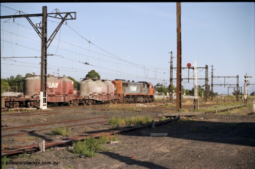 141-2-19
Sunshine, broad gauge V/Line X class X 45 'Edgar H Brownbill' Clyde Engineering EMD model G26C serial 75-792 leads an up Bendigo goods train through Sunshine bound for Tottenham Yard, in this trailing view two VPCX class bogie cement waggons are leading consist.
Keywords: X-class;X45;Clyde-Engineering-Rosewater-SA;EMD;G26C;75-792;