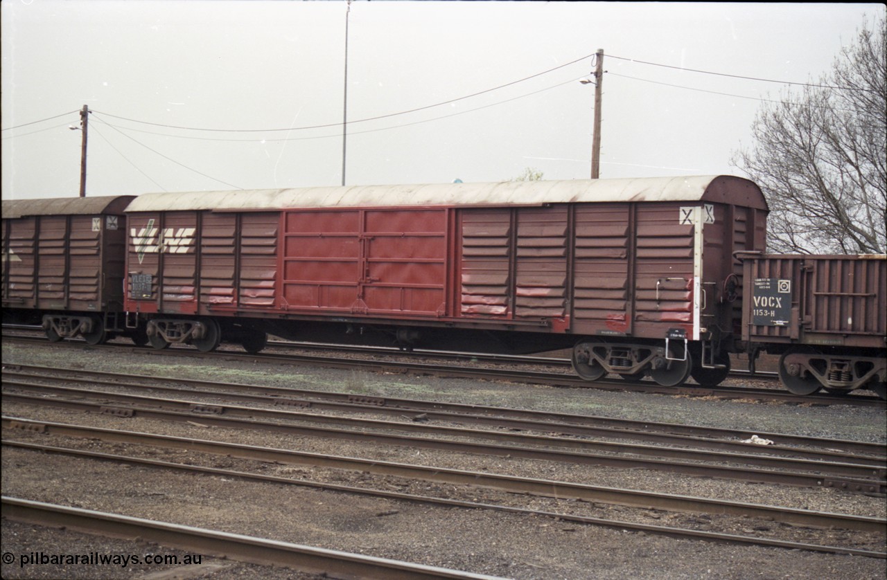142-1-37
Benalla yard, V/Line broad gauge VLEX type bogie louvre van VLEX 1037 with fresh painted door, stabled Wodonga goods train 9303. VLEX 1037 was built in July 1976 at Ballarat North Workshops as a VSX type, recoded to VLEY in October 1979, then VLEX in December 1982.
Keywords: VLEX-type;VLEX1037;Victorian-Railways-Ballarat-Nth-WS;VSX-type;