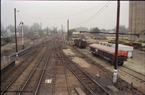 142-2-02
Wangaratta station yard overview looking south from footbridge, semaphore signal post 12 pulled off for up train, fuel siding is visible on the left, standard gauge line is in the cutting at far left, signal gantry in the distance, V/Line VOCX and VOFX type bogie open waggons at right.
Keywords: VOCX-type;VOFX-type;