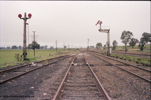 142-2-07
Barnawartha, yard overview looking north, disc signal post 9, semaphore signal posts 10, 11 and 18? pulled off indicating signal box switched out, derails on siding tracks, standard gauge on the far right.
