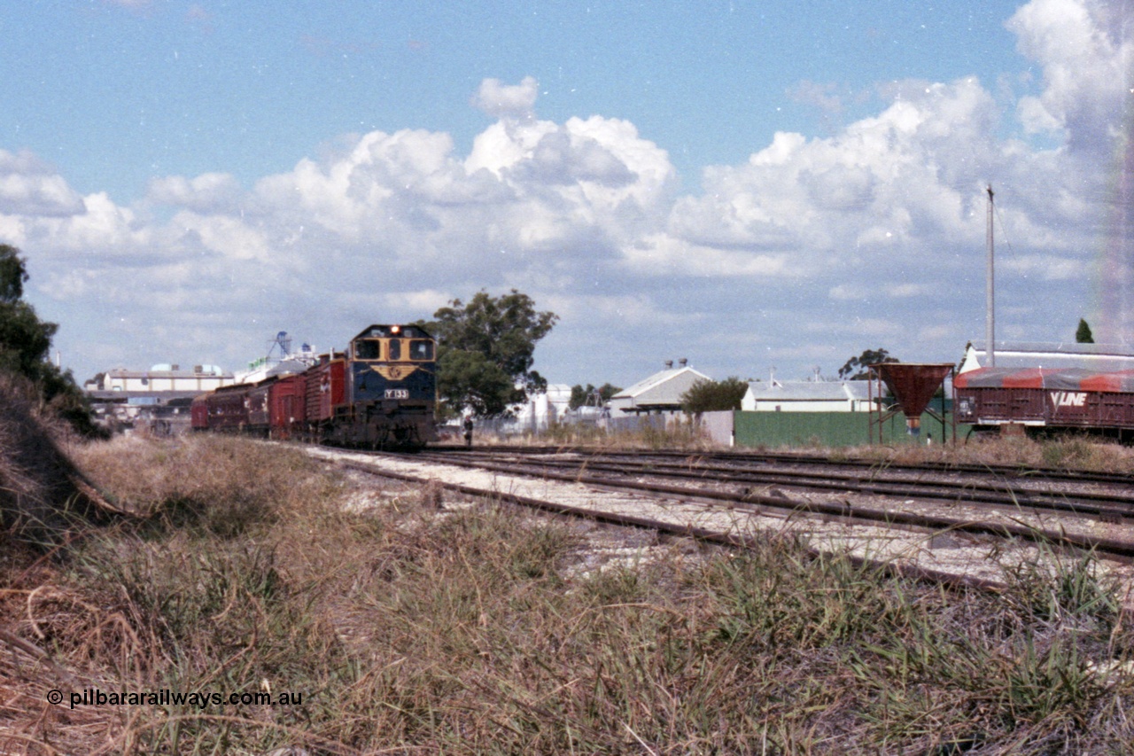 143-25
Wahgunyah, broad gauge VR liveried Y class Y 133 Clyde Engineering EMD model G6B serial 65-399 leads the arriving 'Stringybark Express' mixed special into the yard past the V/Line VOFX type bogie super phosphate waggons and sheds on the right, Uncle Tobys in the background.
Keywords: Y-class;Y133;Clyde-Engineering-Granville-NSW;EMD;G6B;65-399;