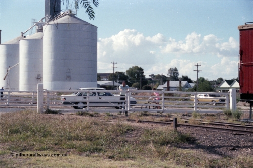 143-37
Rutherglen, the non-interlocked hand operated swing gates on Howlong St are closed following the departure of the up 'Stringybark Express' mixed special, the trailing edge of ZL 2 just visible, Ascom silos in the background.
