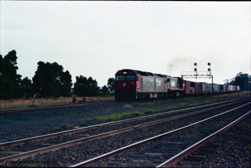 145-21
Wallan Loop, north end of standard gauge loop, V/Line G class G 526 model JT26C-2SS serial 88-1256 leads V/Line 3rd series X class with a down Albury bound goods pass under the signal gantry, broad gauge lines in the foreground.
Keywords: G-class;G526;Clyde-Engineering-Somerton-Victoria;EMD;JT26C-2SS;88-1256;