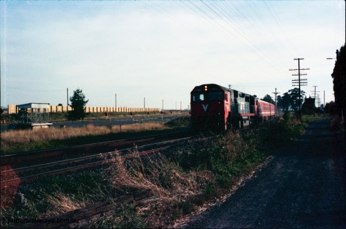 145-25
Wallan, down broad gauge passenger train hauled by V/Line N class N 469 'City of Morwell' Clyde Engineering EMD model JT22HC-2 serial 86-1198 and N set past the remains of disc signal post 15, at left is the 'Gang Camp' area with sound proofing wall.
Keywords: N-class;N469;Clyde-Engineering-Somerton-Victoria;EMD;JT22HC-2;86-1198;