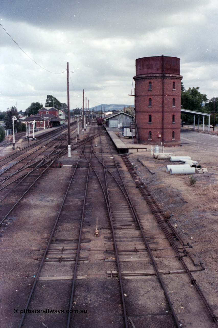 148-34
Wangaratta yard looking south (Up direction) from footbridge, from extreme left, Siding 'A', Signal Post 20 pulled off, Main Line or No. 1 Road, No. 2 Road, No. 3 Road, No. 4 Road and No. 5 Road, goods shed and platform and water tower with Freight Gate awning behind, point rodding and signal wires visible.
