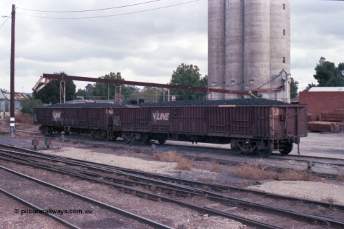 148-14
Wangaratta, V/Line VOCX bogie open waggons, VOCX 122, loaded with briquettes on the old works platform road, looking towards Sidings E, silos in the background. VOCX 122 was built by Ballarat North Workshops May 1968 as ELX type ELX 122. In 1979 re-coded to VOCX. In 1994 re-coded to ROBX.
Keywords: VOCX-type;VOCX122;Victorian-Railways-Ballarat-Nth-WS;ELX-type