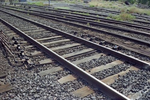 149-13
Bacchus Marsh, track view of point rodding changing track sides under rails with pivots.
