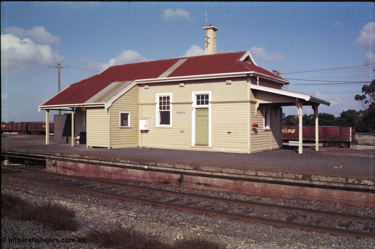 151-10
Gheringhap station building overview, platform and coping, taken from site of former No.2 platform, staff exchange box visible, gypsum waggons in yard behind station building.
