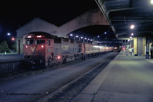 153-3-21
Geelong station building and platform, night shot, V/Line broad gauge N class N 467 'City of Stawell' Clyde Engineering EMD model JT22HC-2 serial 86-1196 with a 5 car N set prepares to cut off, driver looking at 2nd person on ground.
Keywords: N-class;N467;Clyde-Engineering-Somerton-Victoria;EMD;JT22HC-2;86-1196;