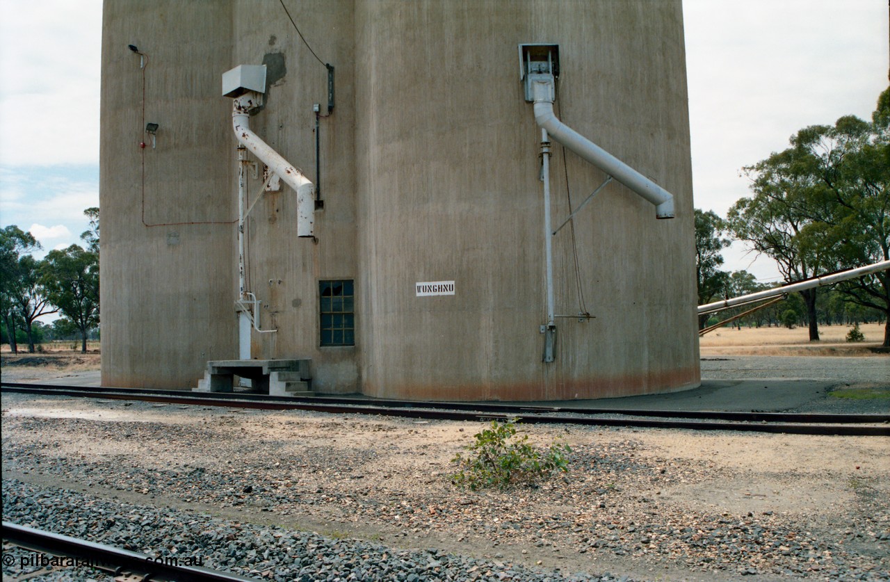 156-21
Wunghnu, station name painted on Williamstown style silos, train out loading spouts.
