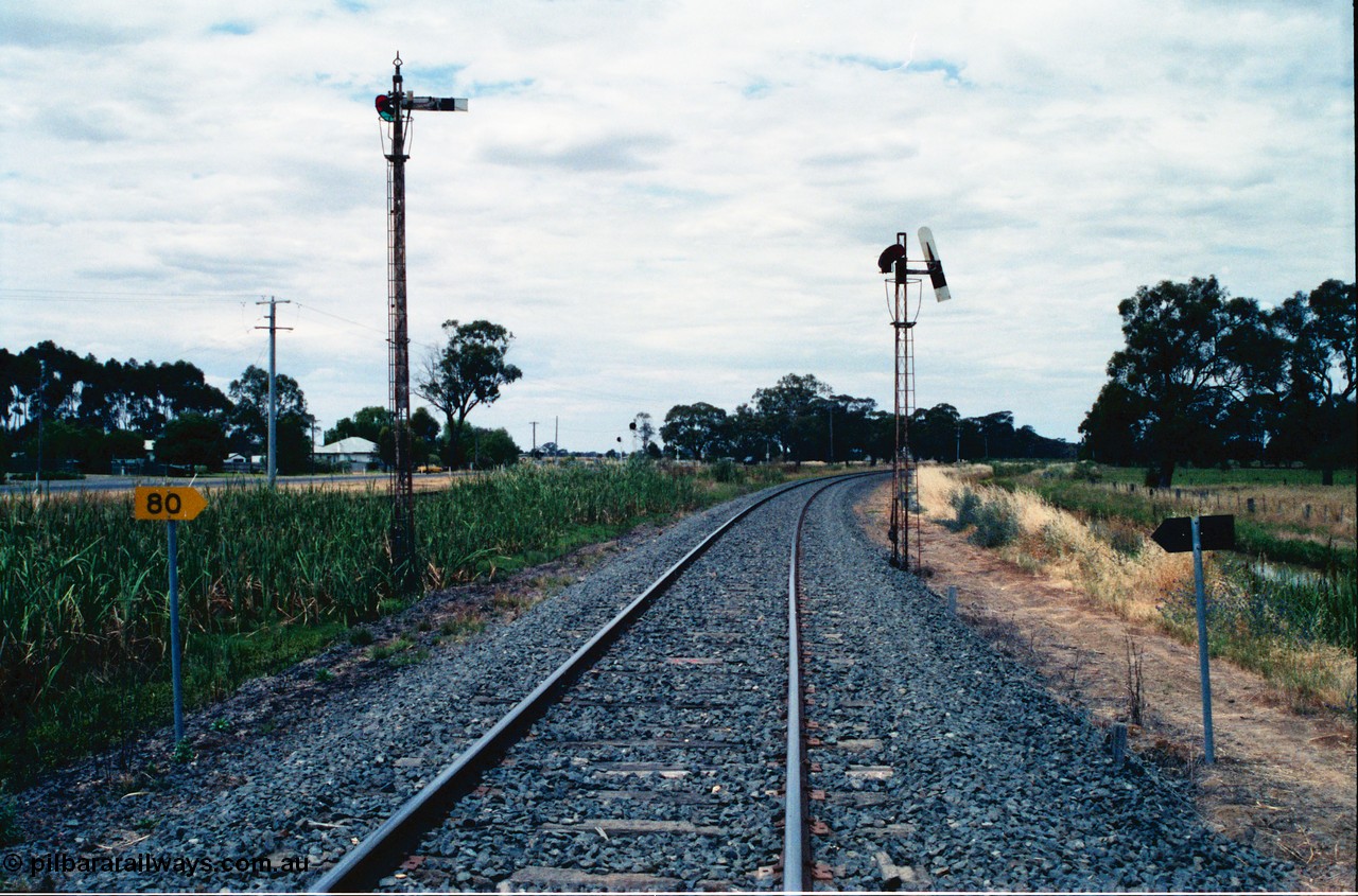 156-25
Numurkah, Picola Junction looking north, up home semaphore signal posts for the Picola line at left and the Strathmerton line on the right, I'm standing on the Strathmerton line and the up home signal is pulled off, 80 km/h speed board.
