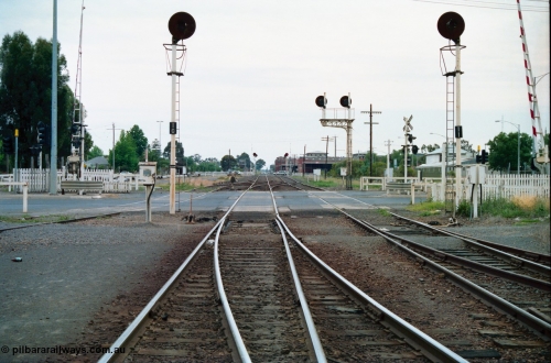 156-09
Shepparton yard view looking north across High Street grade crossing from No.2 Road and the Tocumwal mainline, points for former 'engine track' are on the right, points for the road from the Tocumwal line to No.1 Road set, line on the right is to Katamatite, searchlight signal posts 10 and 11 are the down home signals for each line, track on the far left cross High Street and is the former SEC Siding, SPC Siding can be seen on the right in the distance beyond searchlight signal posts 14 and 15, both down homes.
