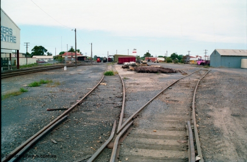 156-10
Shepparton station yard overview looking south down No.5 Road towards the goods shed and stabled T class, fuel train and louvre vans, the former Fruit Siding curves around the back of the goods shed at right, grounded B van and per way stockpiles of rails and pipes in middle of frame, station building and platform on the left, awning for unloading gantry of  J. Murray More Pty Ltd or Tubemakers at left over former Engine Track.
