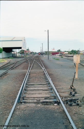 156-12
Shepparton station yard overview, looking south from High Street, mainline points from the Tocumwal line set for No.1 or platform Road, showing point lever, interlocking and telephone cabinet, line on the left is to Katamatite, now Dookie and the former Engine Track heading into the  J. Murray More Pty Ltd or Tubemakers awning for the unloading gantry, yard roads, goods shed, Freightgate and cement silos in the background right hand side.
