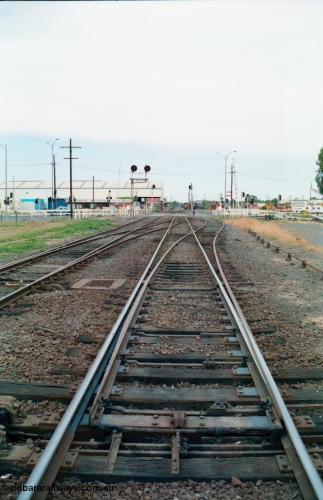 156-14
Shepparton station yard overview looking south across the High Street grade crossing from the mainline crossovers and points for the yard, searchlight signal post 12, Up home, Katamatite, now Dookie line at left, standing on Tocumwal line.
