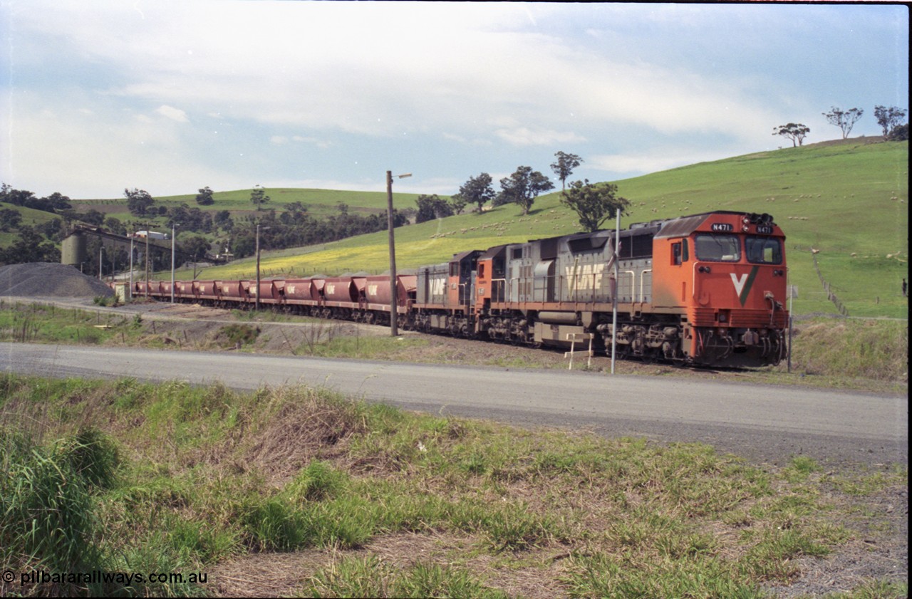 157-31
Kilmore East, Apex Quarry Siding, V/Line broad gauge locomotives N class N 471 'City of Benalla' Clyde Engineering EMD model JT22HC-2 serial 87-1200 and T class T 390 Clyde Engineering EMD model G8B serial 65-420 with train under the loading bins during loading operations, view across Broadford - Kilmore Road.
Keywords: N-class;N471;Clyde-Engineering-Somerton-Victoria;EMD;JT22HC-2;87-1200;