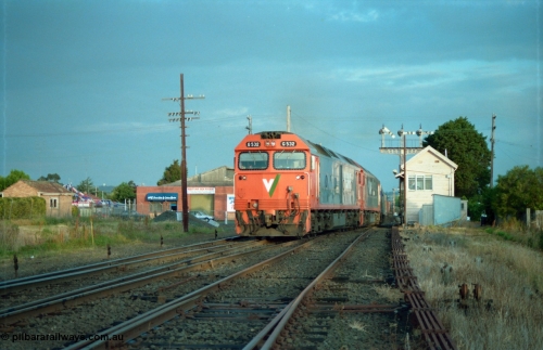 159-21
Ballarat D Signal Box, Linton Junction, V/Line broad gauge G class G 532 Clyde Engineering EMD model JT26C-2SS serial 88-1262 leads a sister with a down Adelaide bound goods train across Gillies Street triple doll semaphore signal post 20 is pulled off for the Ararat line as the train swings off the down line which becomes the Linton line, with the Cattle Yard line points just visible, points and track work, interlocking and point rodding.
Keywords: G-class;G532;Clyde-Engineering-Somerton-Victoria;EMD;JT26C-2SS;88-1262;