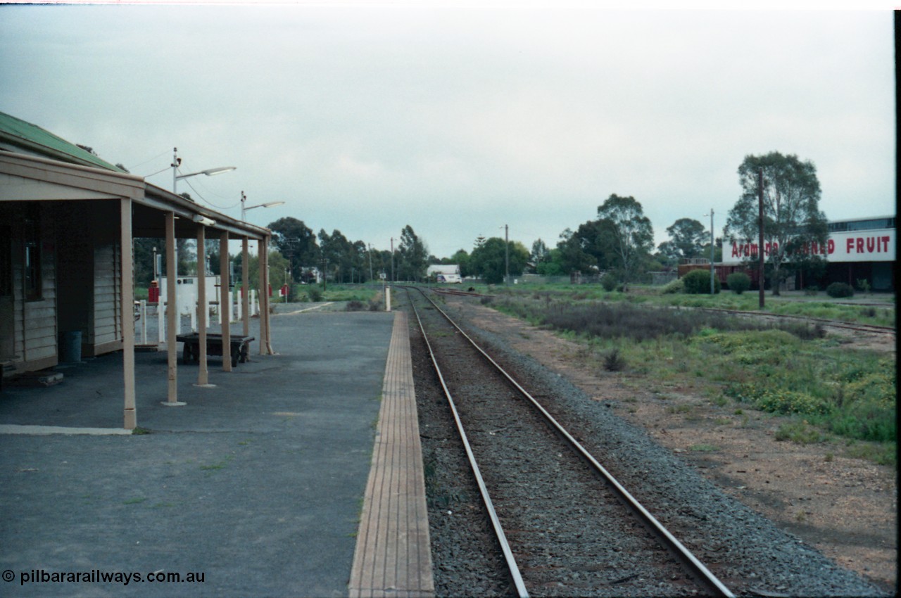 160-14
Mooroopna, view from station platform looking towards Melbourne, station building and platform trolley at left, Ardmona Canned Fruit loading sidings at right, on the left beyond the station building is the hard stand area for the mobile gang camp, with caravan type plugs and permanent ablution block.
