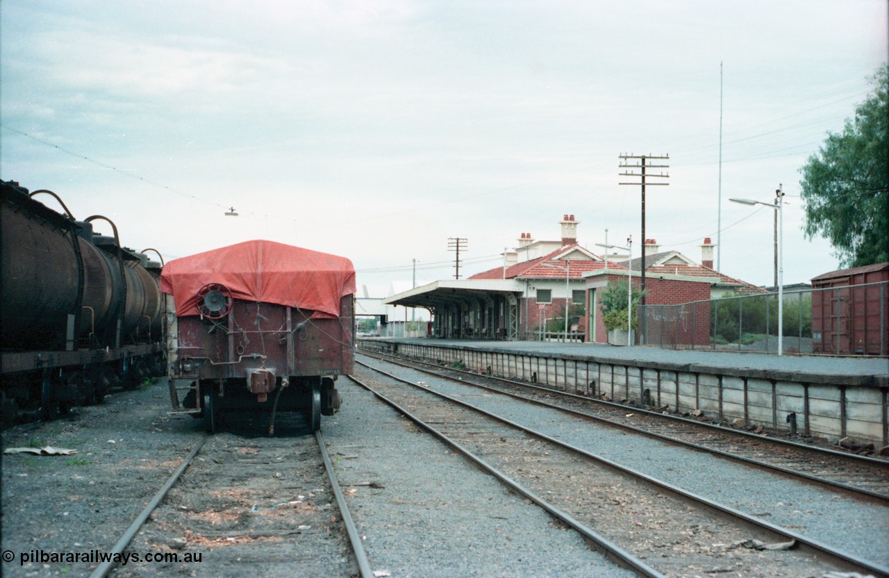 160-20
Shepparton yard view, stabled fuel train on No.4 Rd at left, hand brake end of super phosphate waggon, rear of stabled Shepparton goods train on No.3 Rd, station building and platform on the right.
