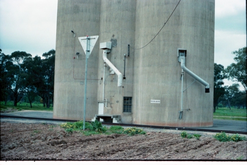 160-35
Wunghnu, track view from former station building site looking across tracks to Williamstown style silo complex, train load-out spouts, rear of location sign.
