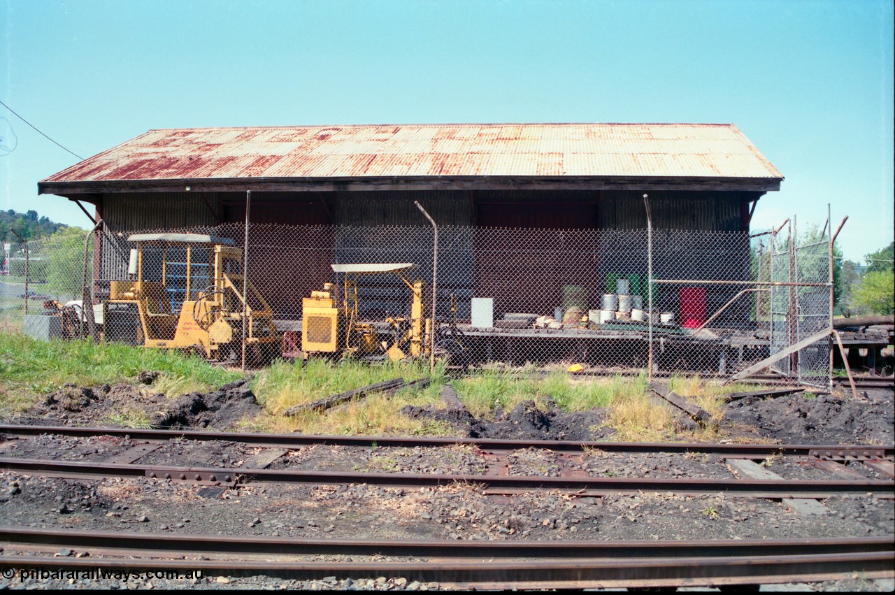 162-1-05
Healesville, front view elevation of goods shed with fenced off compound with track machines, yard tracks in foreground.
