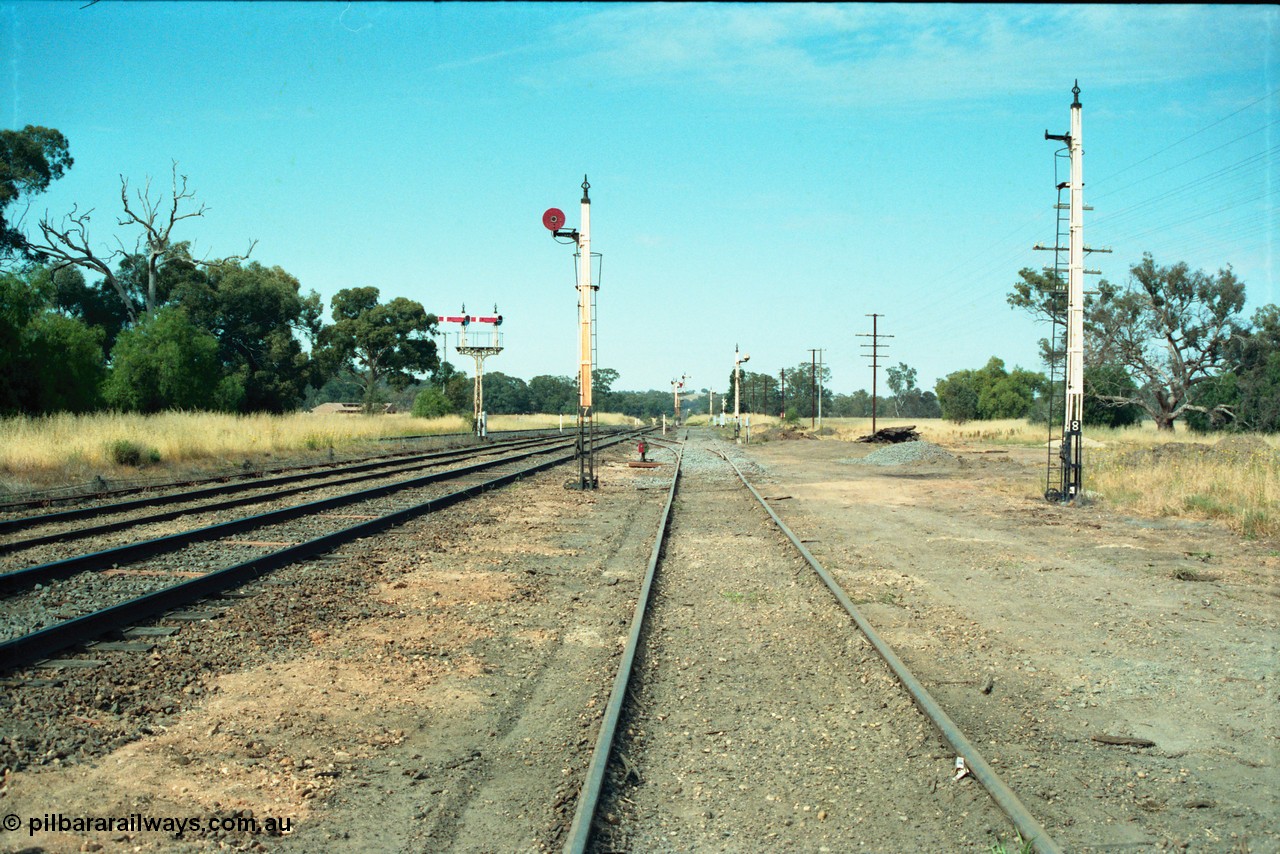 163-19
Avenal station yard overview looking south along No.3 Road, with Siding A and new points to mainline beyond disc signal post 7, disc signal post 8 and No.5 Road stripped, semaphore signal post 6 for up trains and down facing signals still intact, standard gauge line can be seen on the left.
