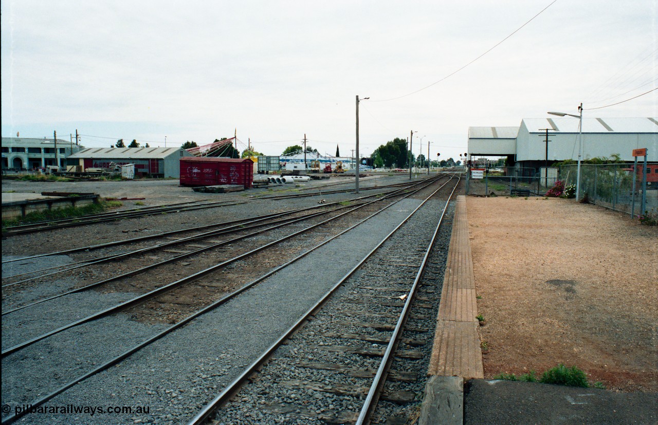 163-25
Shepparton station yard overview looking north from platform, the platform road is the line to Katamatite, with No.2 Road the line to Tocumwal, loading platform just visible and grounded B van.
