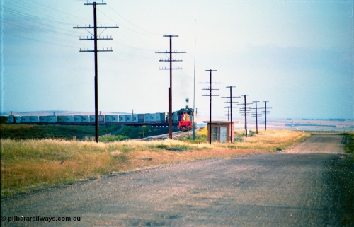 163-02
Bank Box Loop, broad gauge down V/Line Adelaide bound good train rounding the curve on approach behind a third series X class and Australian National BL class, TNT and FCL containers, east end interlocking room and radio mast.
