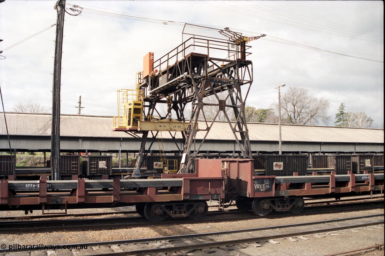 165-25
Albury yard view with Demag transhipping gantry crane with 30 ton spreader bar for lift steel slabs, trans-shipping shed, V/Line broad gauge bogie slab steel waggons of the VKEX class VKEX 1 and NSWSRA NRJY class in the background
