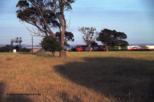 168-05
Bank Box Loop, down V/Line broad gauge goods train to Adelaide behind G class G 540 Clyde Engineering EMD model JT26C-2SS serial 89-1273 and Australian National 700 class 704 AE Goodwin ALCo model DL500G serial G6059-2 stand at the down end of the crossing loop on the mainline awaiting a cross with an up passenger train.
Keywords: G-class;G540;Clyde-Engineering-Somerton-Victoria;EMD;JT26C-2SS;89-1273;