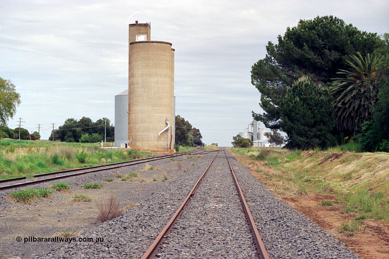 170-03
Dookie, yard view looking towards Shepparton, or west, Williamstown style silo complex with steel annex, gravitational road and crossover visible, former platform site at right, GEB sub-terminal visible in the distance.
