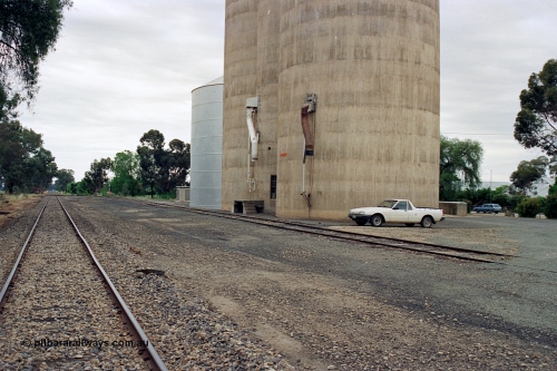 170-13
Devenish yard overview looking towards Oaklands, Williamstown style silo complex with steel annex, load-out spouts, 1988 Ford XF Falcon ute.
